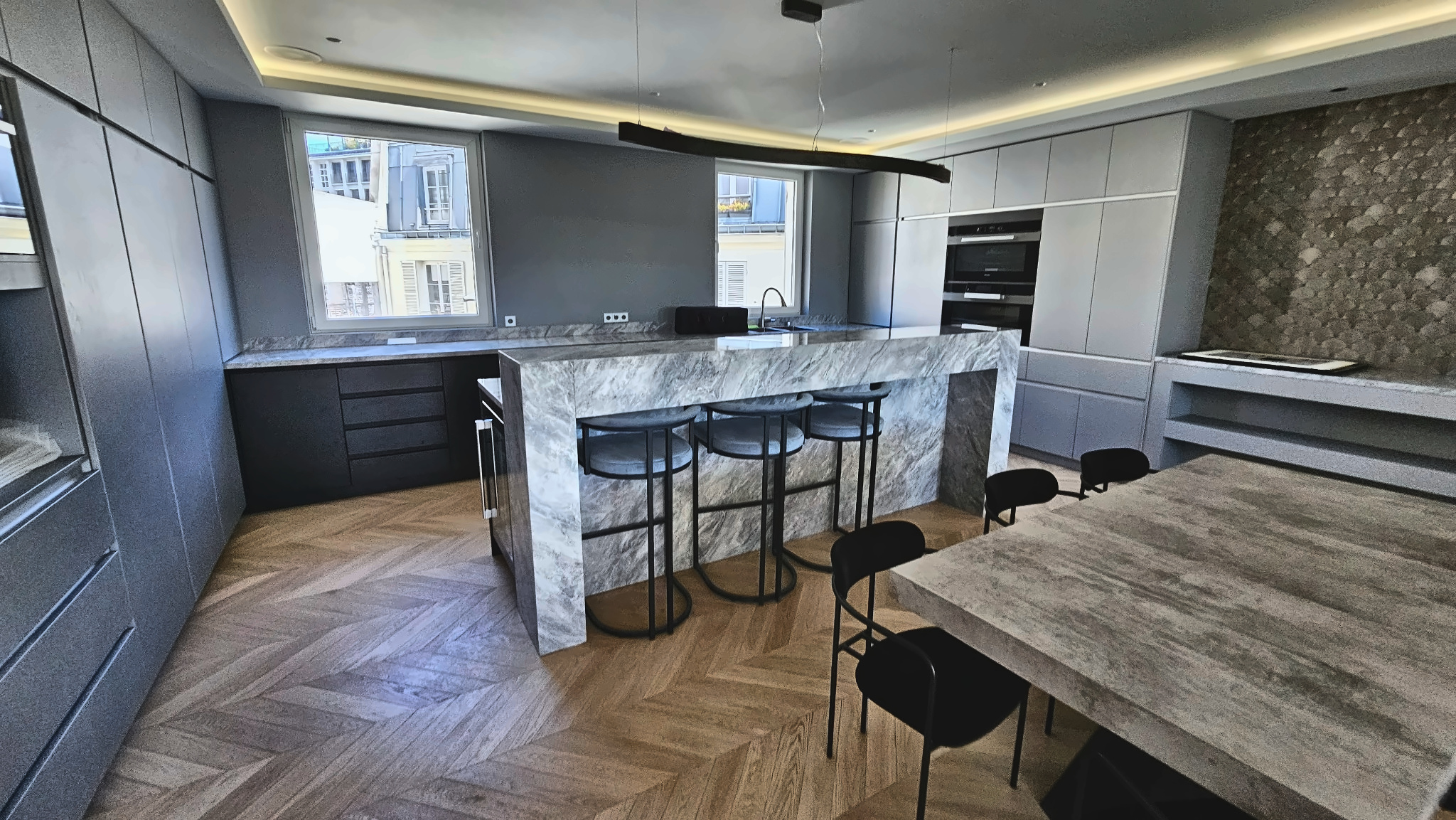 Cuisine rénovée Paris 15e — vue depuis l'îlot marbre vers les fenêtres et le salon AGV Rénov