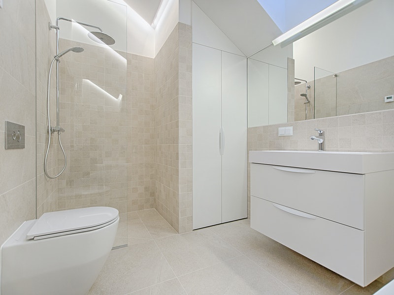 Salle de bain beige minimaliste avec douche à l'italienne